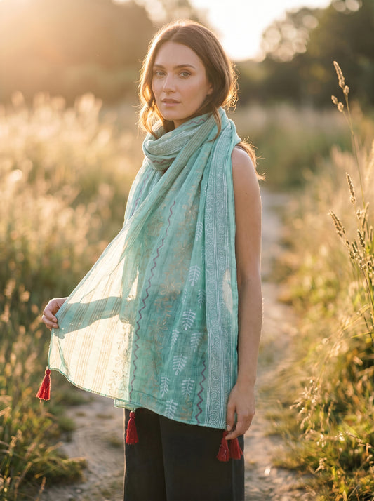 Woman wearing a turquoise scarf with tassels in a natural setting