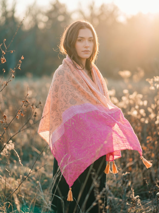 Woman wearing a pink and orange patterned scarf in a natural setting