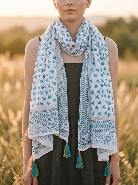 Woman wearing a patterned scarf with tassels in a natural setting