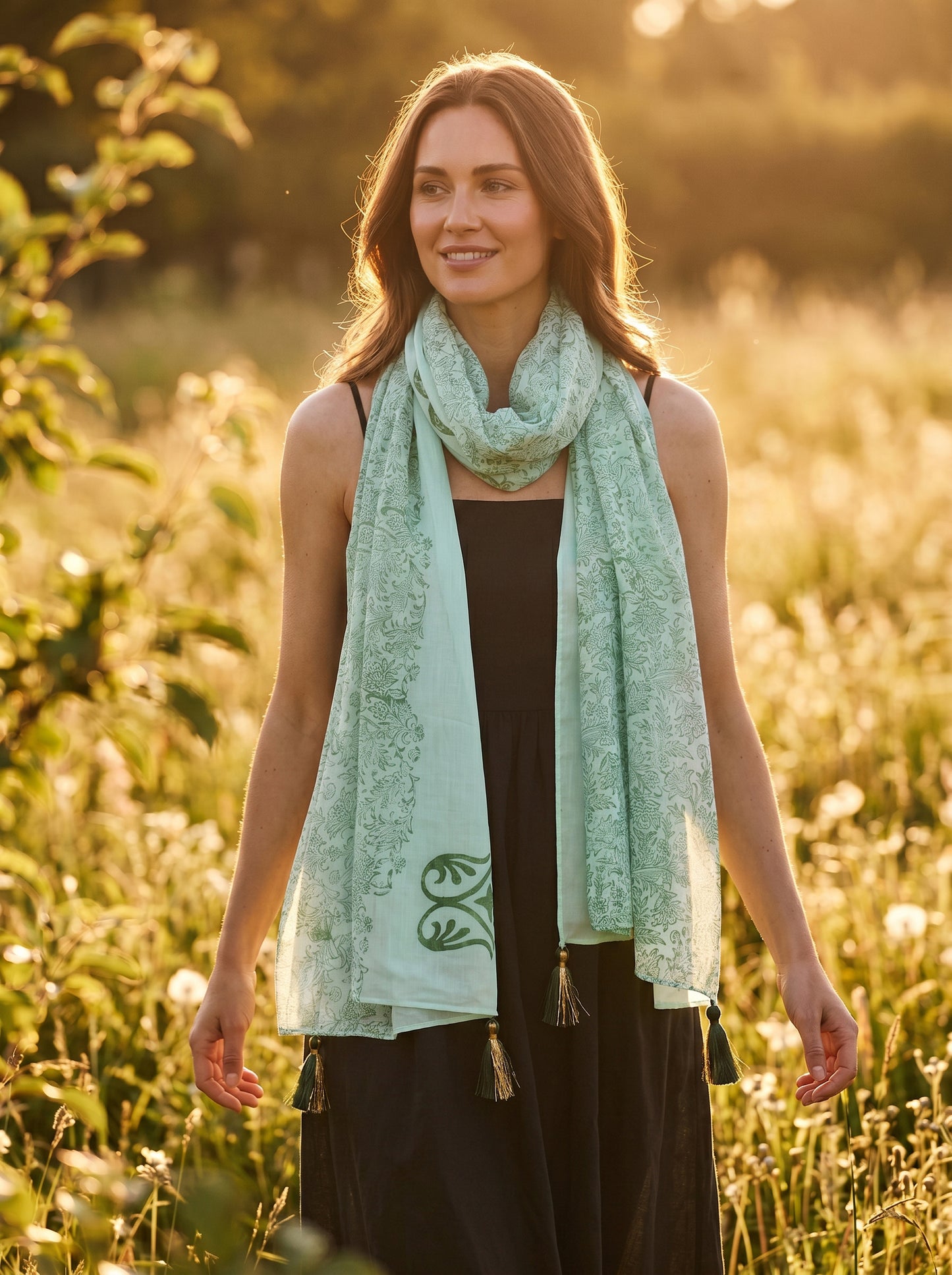 Woman wearing a light green scarf in a sunlit field