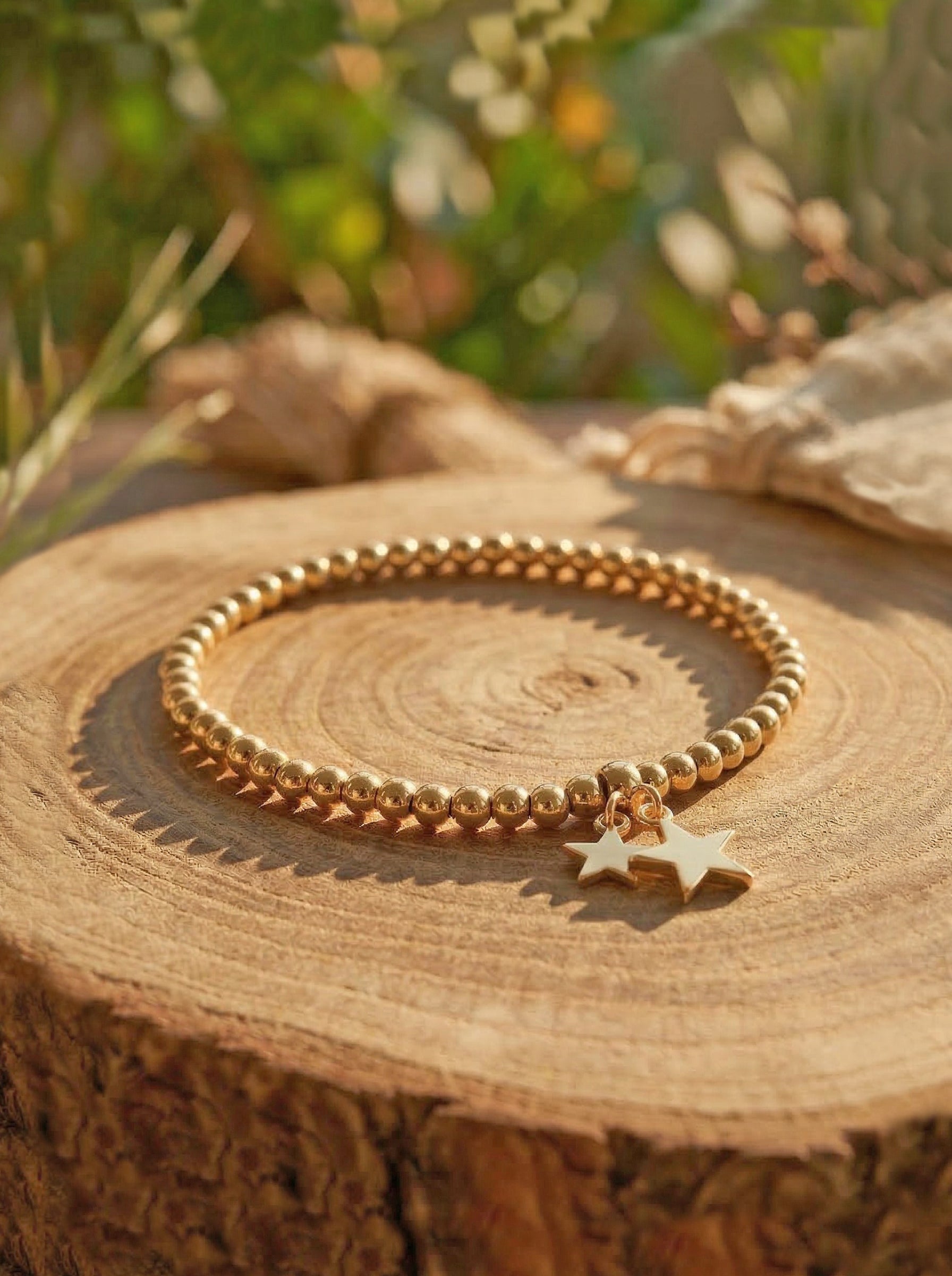 Gold bracelet with star charm on a wooden surface