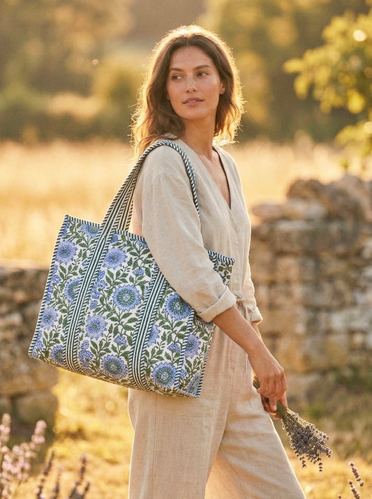 Women wearing a large floral tote bag in an outdoor setting at sunset