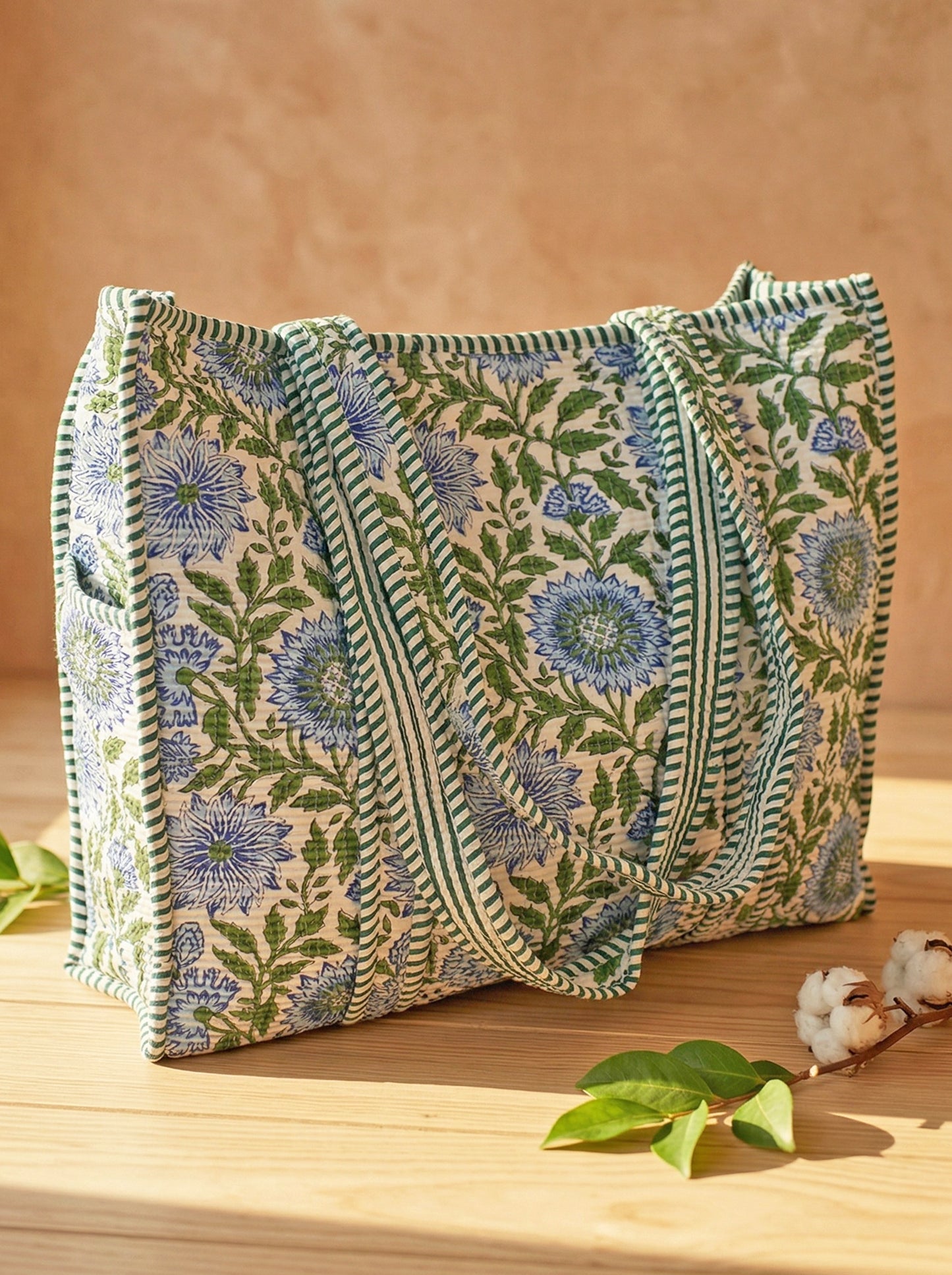 Large floral quilted cotton tote bag on a wooden table