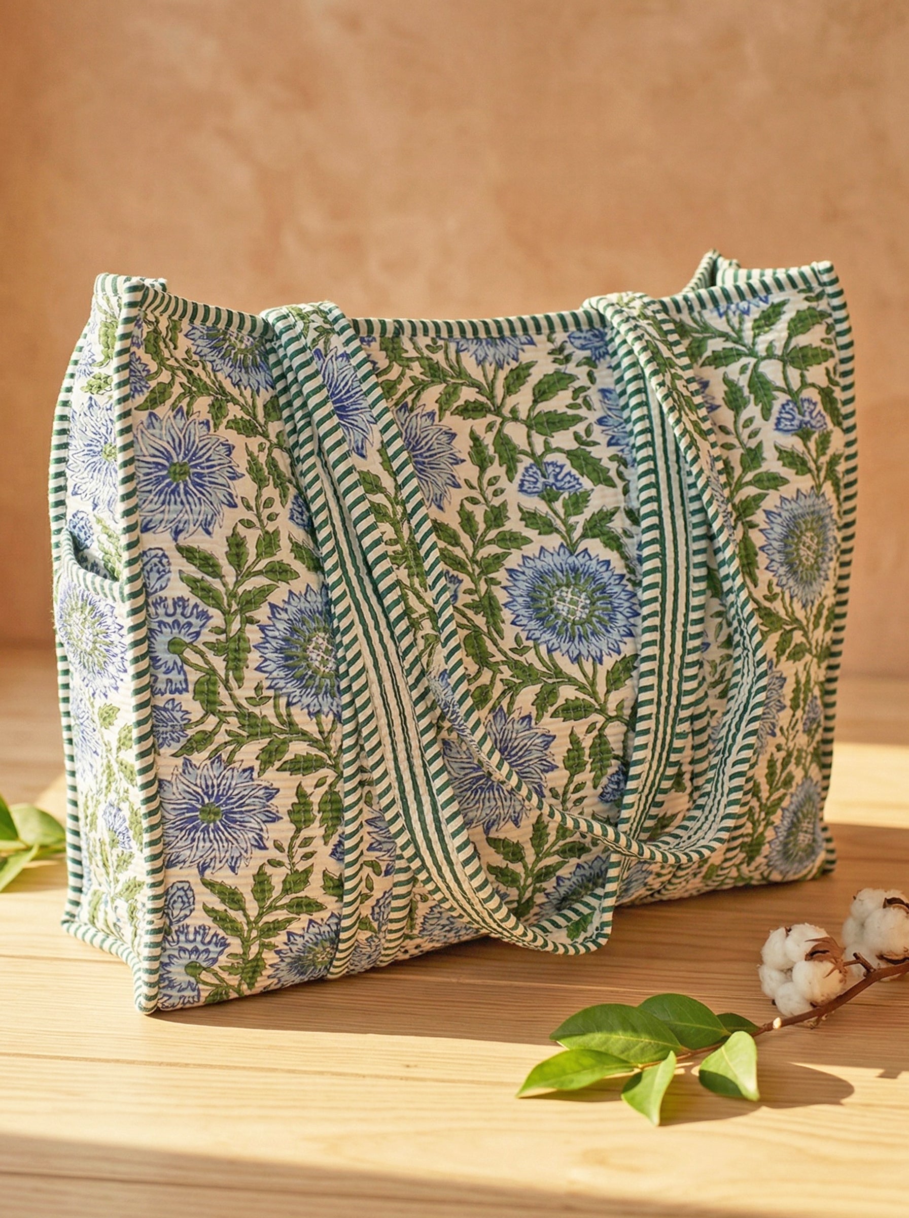 Large floral quilted cotton tote bag on a wooden table