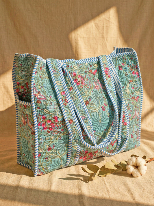 Turquoise floral cotton tote bag on a natural background