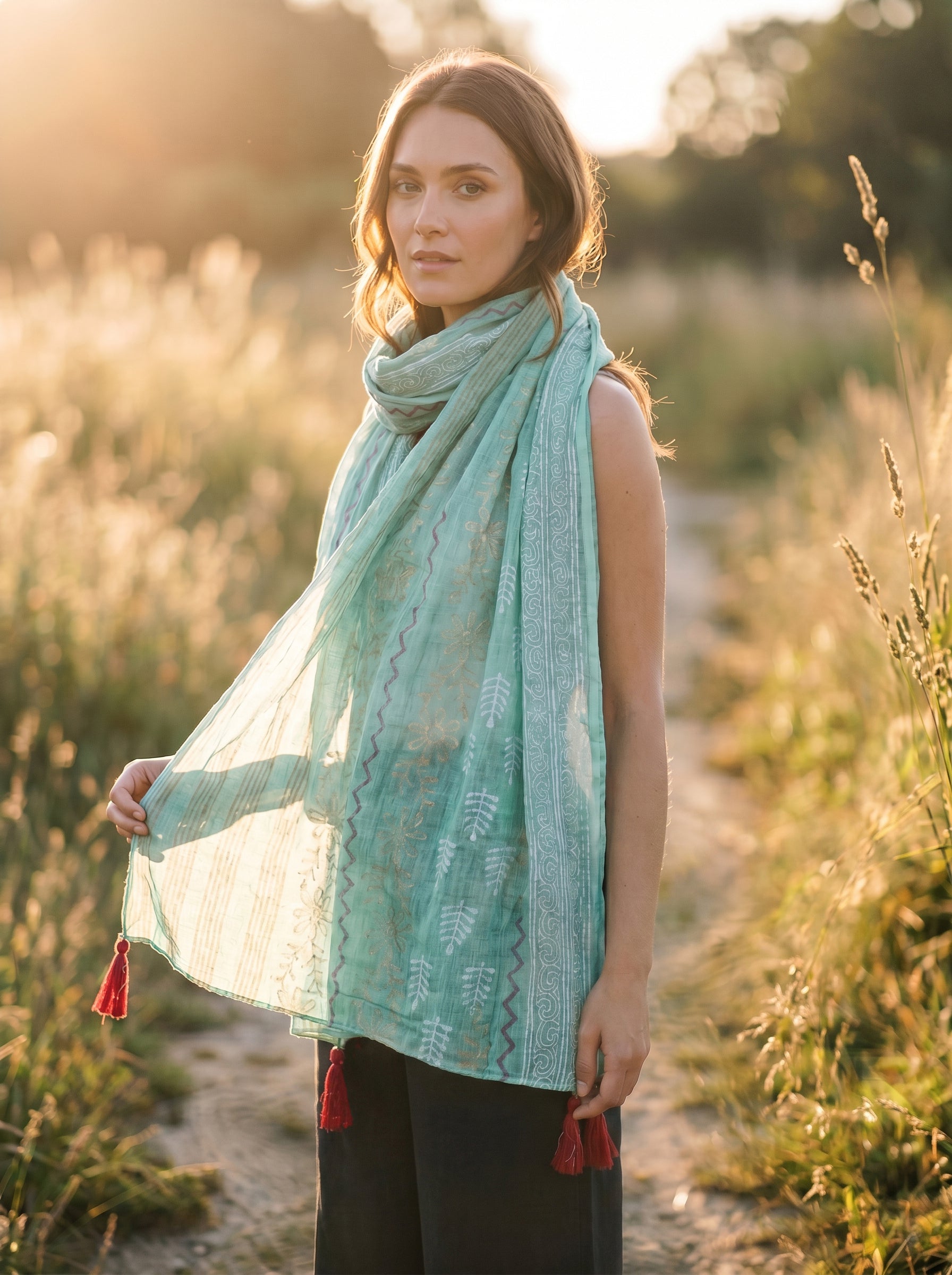 Woman wearing a turquoise scarf with tassels in a natural setting