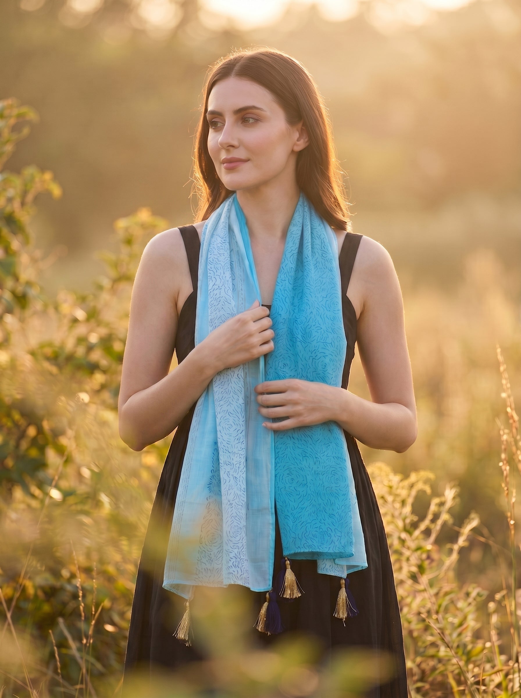 Woman wearing a blue scarf in a natural setting