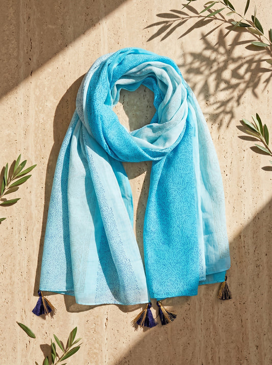 Light blue block printed scarf with tassels on a beige background